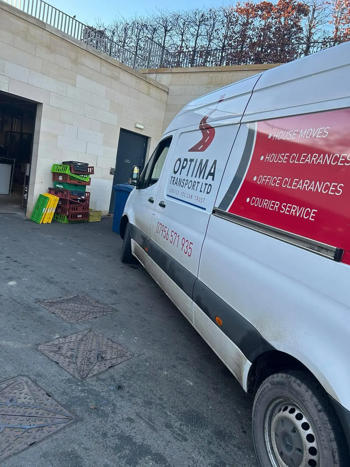 Optima Transport van listing house and office clearances parked at a commercial building