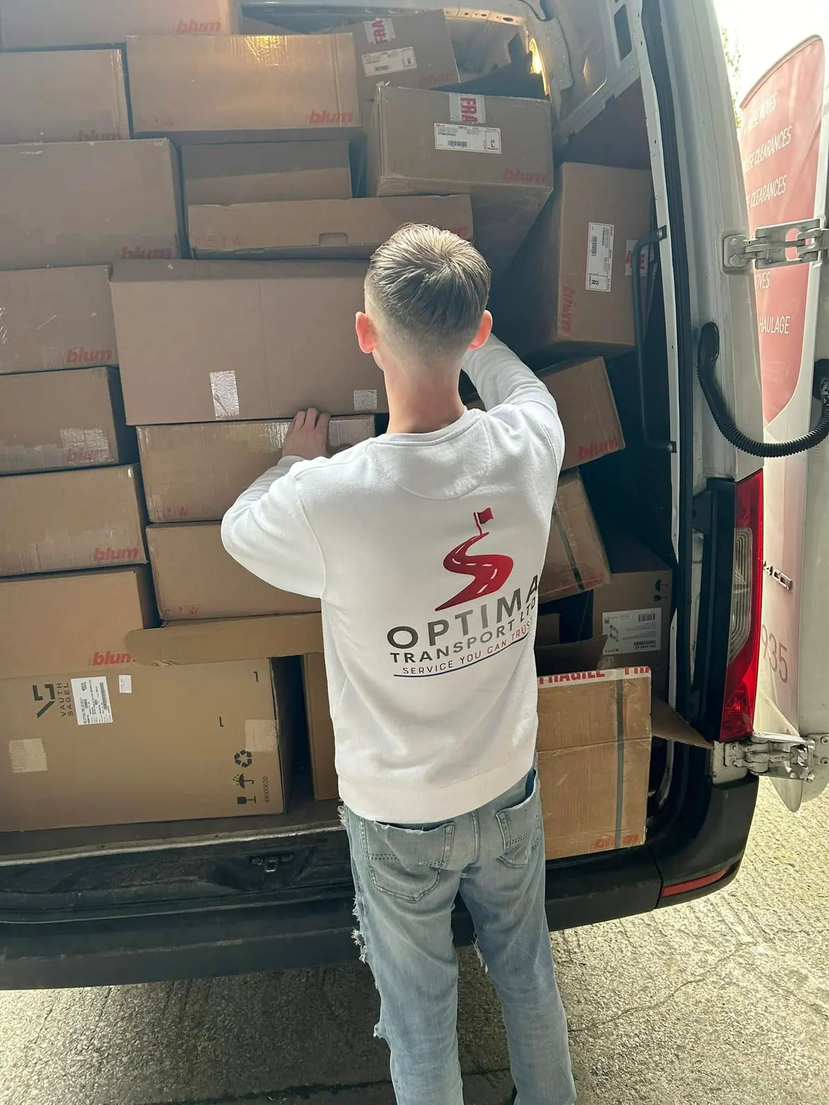 Optima Transport crew member carrying stacked boxes during an office and commercial removal