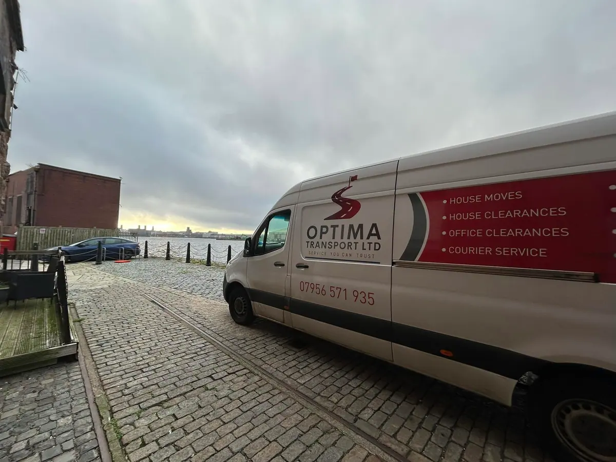 Optima Transport branded van parked on a cobbled quayside, ready for a dedicated removals job