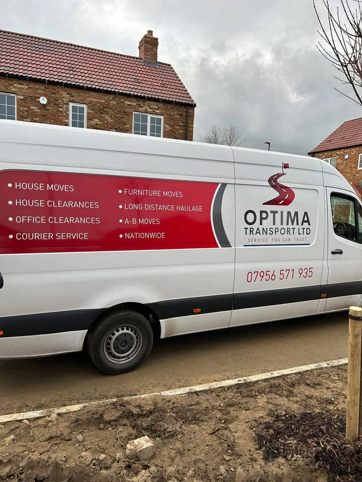 Side of an Optima Transport van showing the company logo and list of services