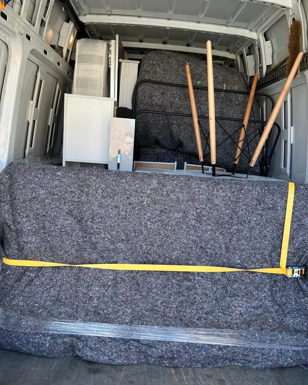 Sofa wrapped in a protective blanket and strapped securely in an Optima Transport van for a York furniture delivery
